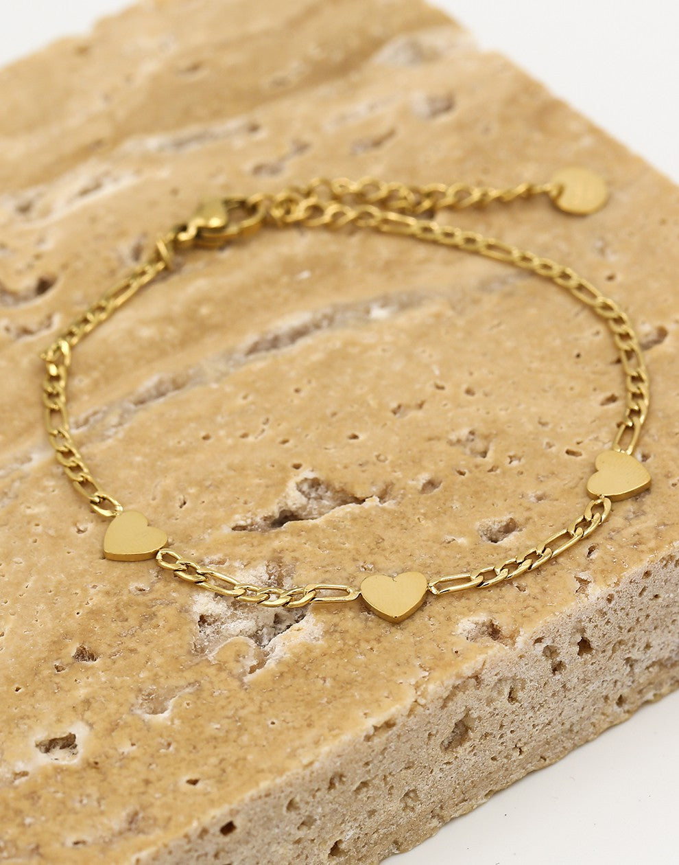 Schakelarmband drie hartjes goudkleurig