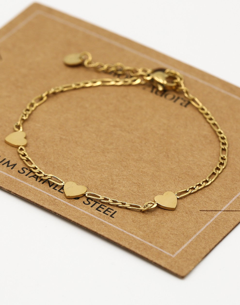 Schakelarmband drie hartjes goudkleurig