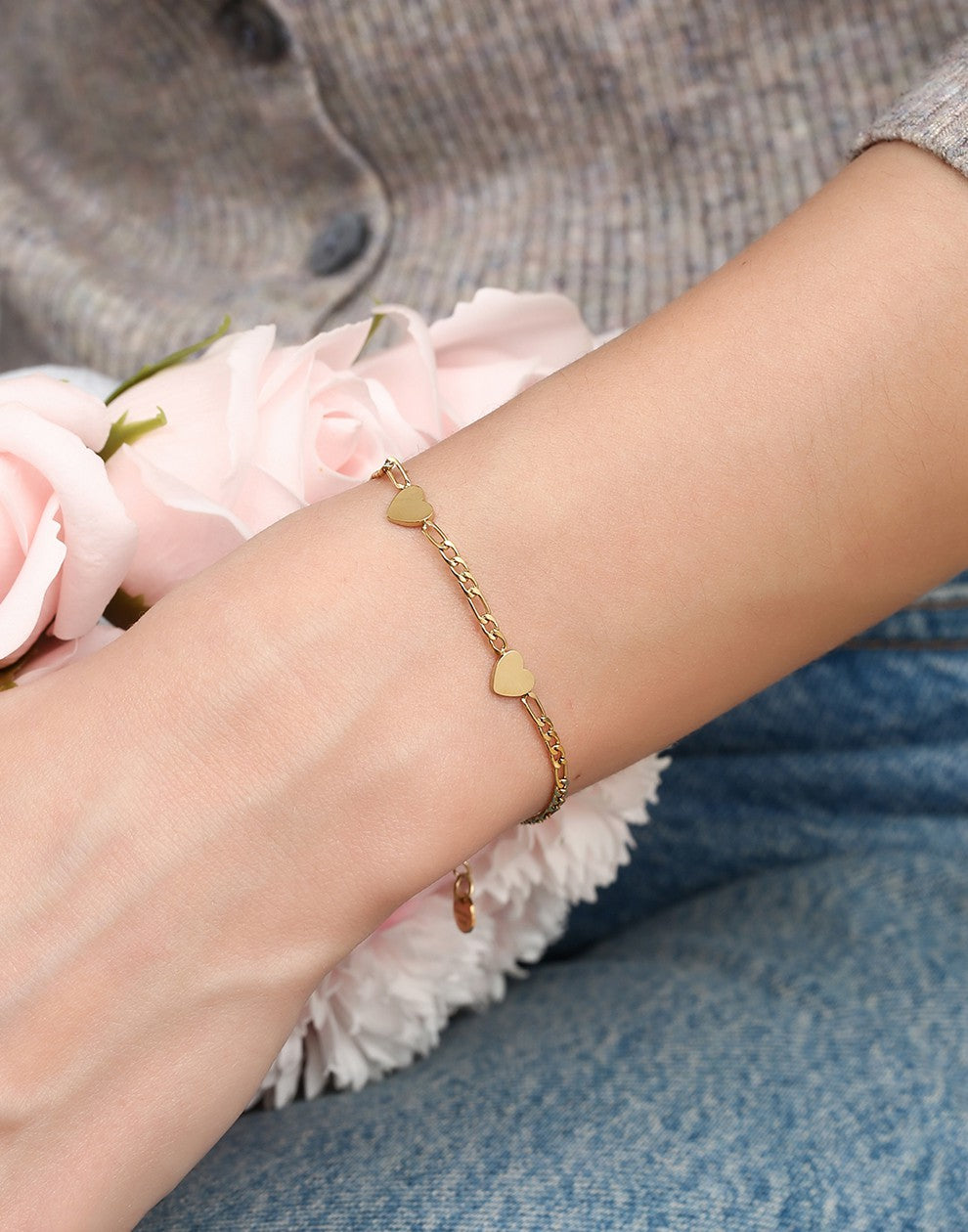 Schakelarmband drie hartjes goudkleurig