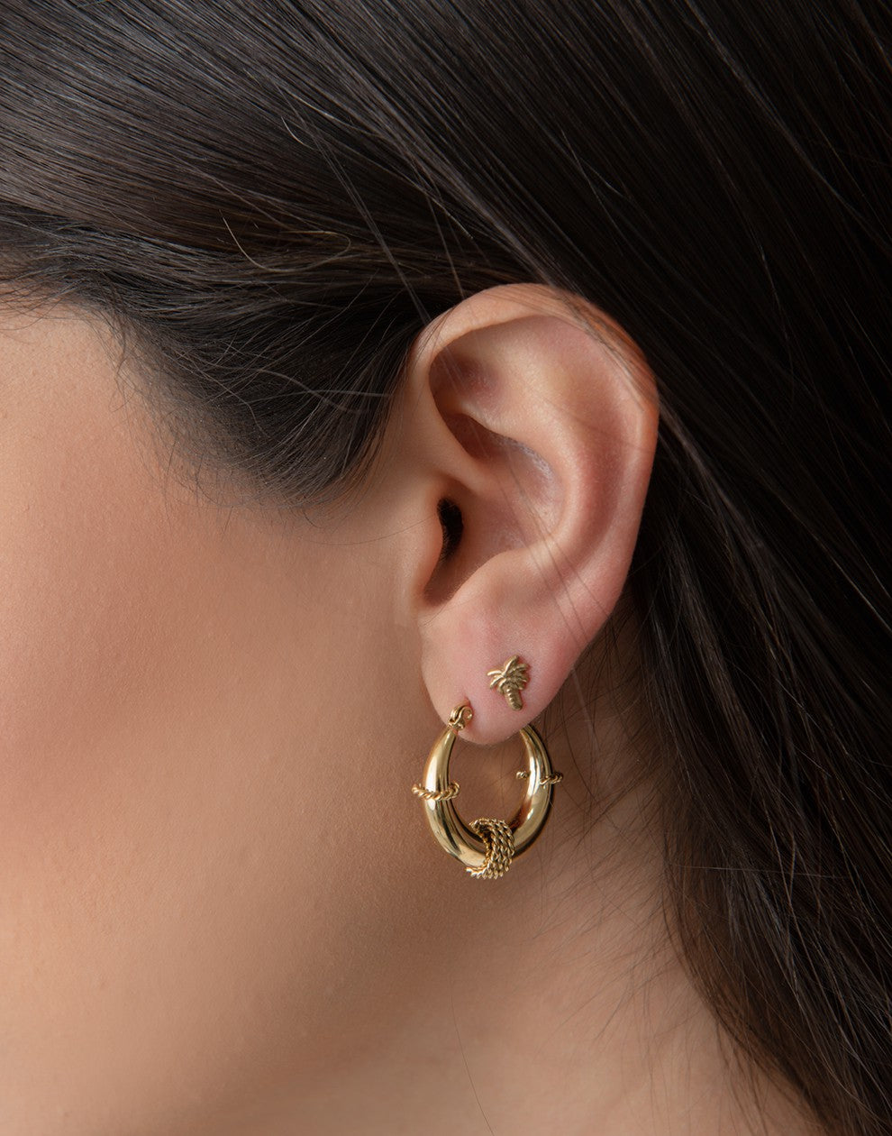 Gold-colored palm tree stud earring