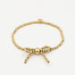 Stretch armband bolletjes strik goudkleurig
