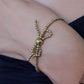 Stretch armband bolletjes strik goudkleurig