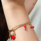 Schakelarmband rode bedels goudkleurig