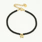 Armbandje zwart met vlinder hanger in het goudkleurig