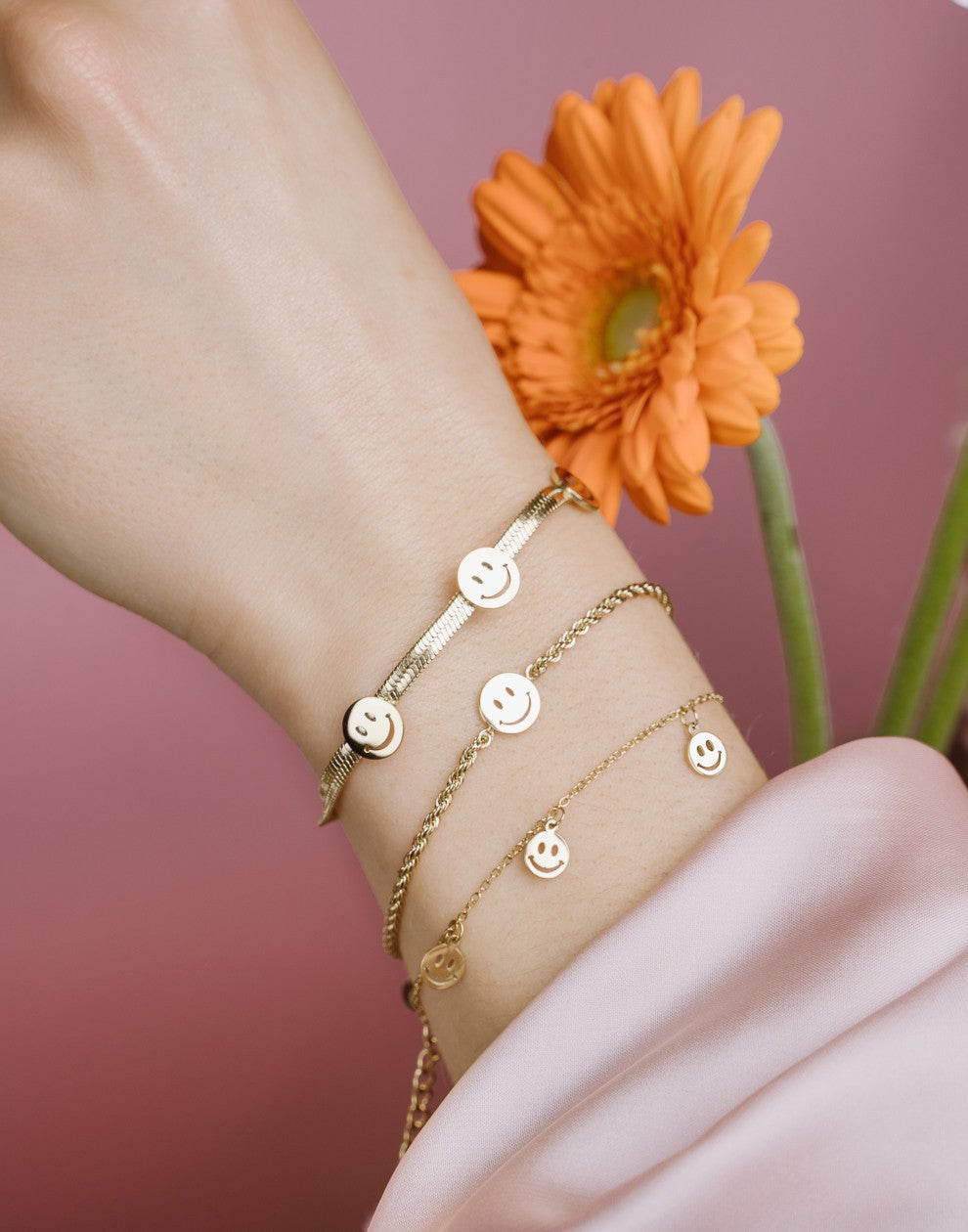 Fijne armband met 5 smiley hangers goudkleurig