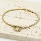 Armband gedraaide schakel met steentjes goudkleurig