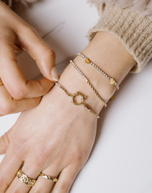 Armband gedraaide schakel met steentjes goudkleurig