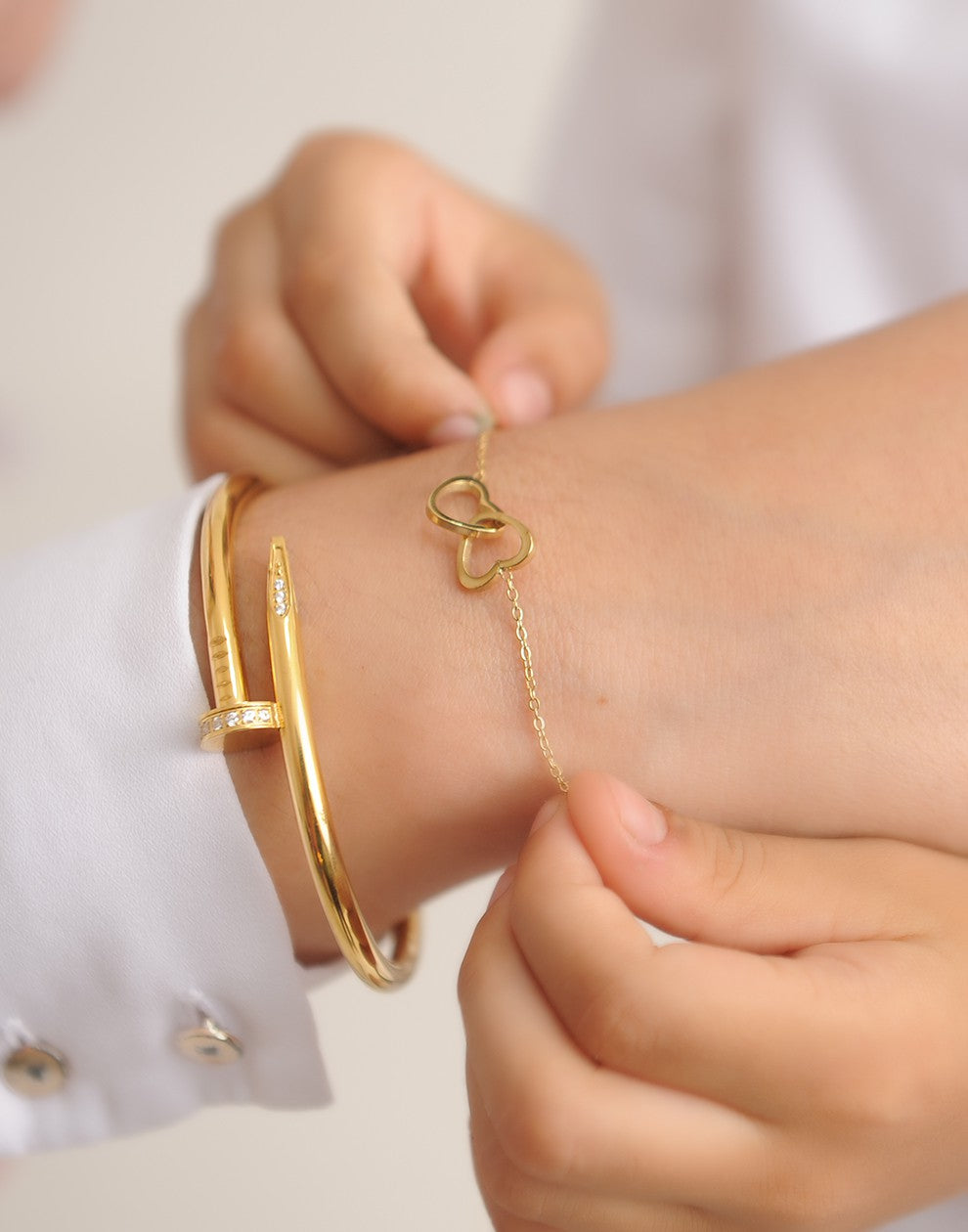 Armband dubbele hartjes met bedel goudkleurig
