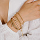 Armbandje roze met vlinder hanger in het goudkleurig
