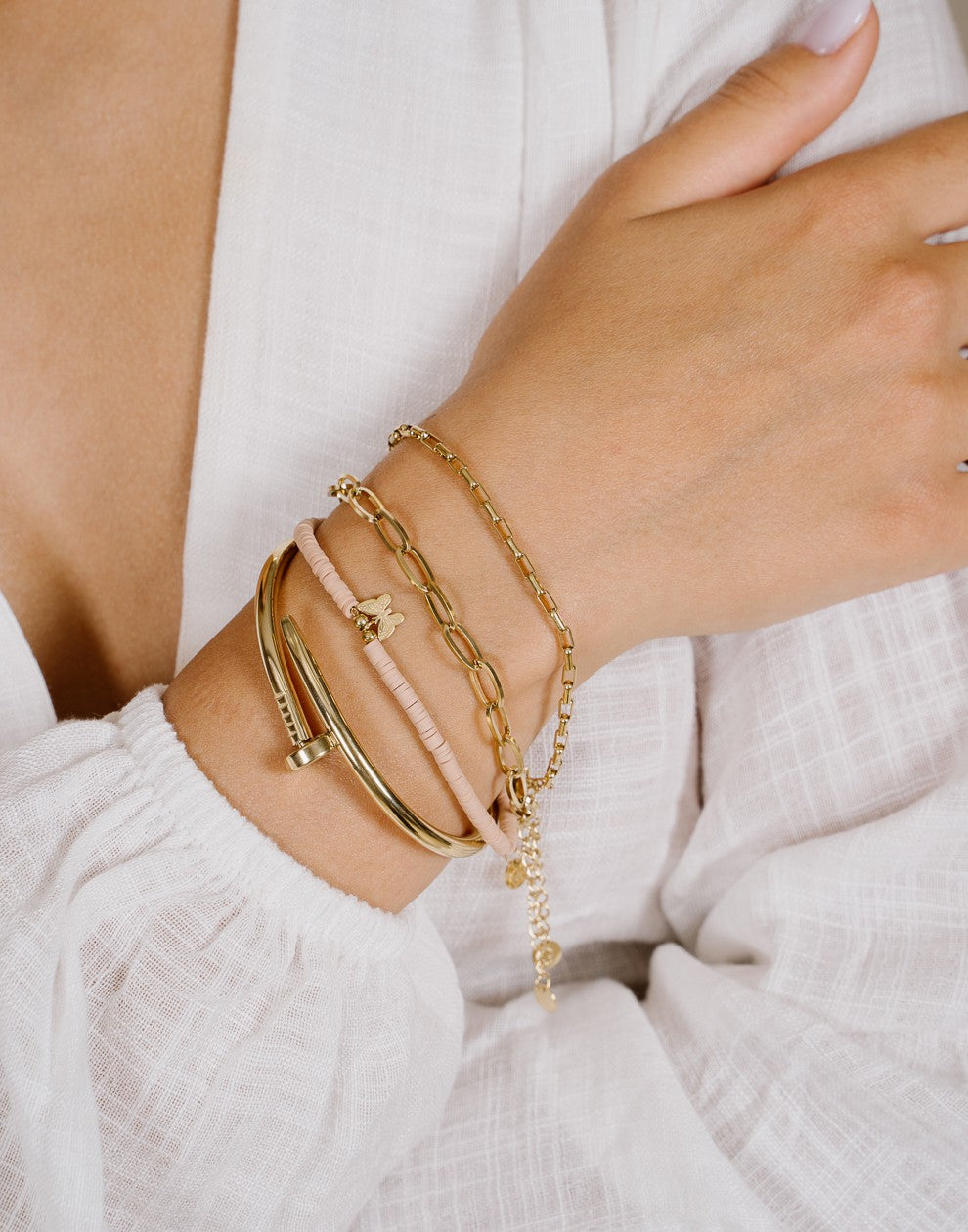 Armbandje roze met vlinder hanger in het goudkleurig