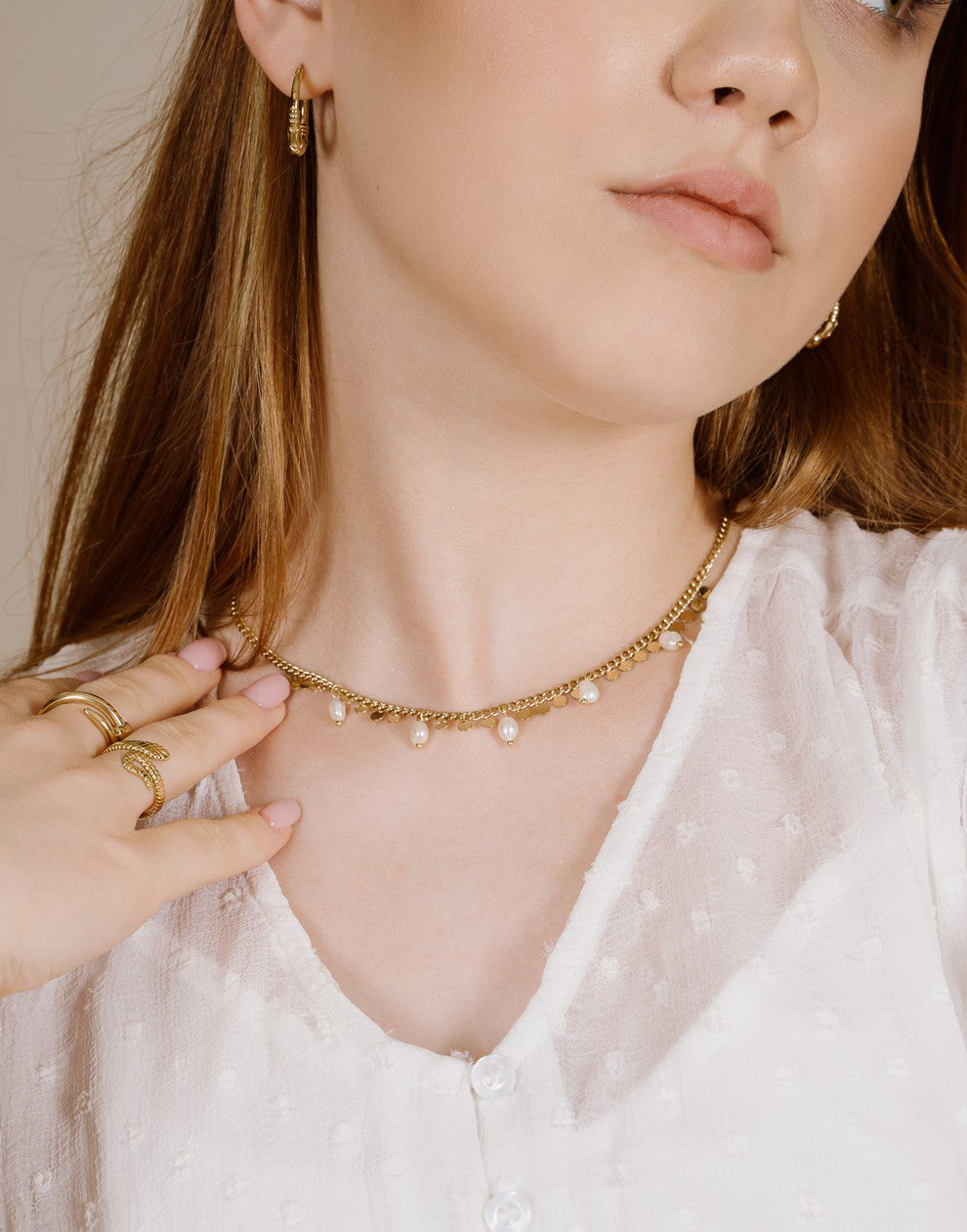 Schakelketting met goudkleurigen muntjes en parels