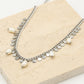 Schakelketting met zilverkleurigen muntjes en parels