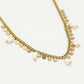 Schakelketting met goudkleurigen muntjes en parels
