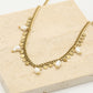 Schakelketting met goudkleurigen muntjes en parels