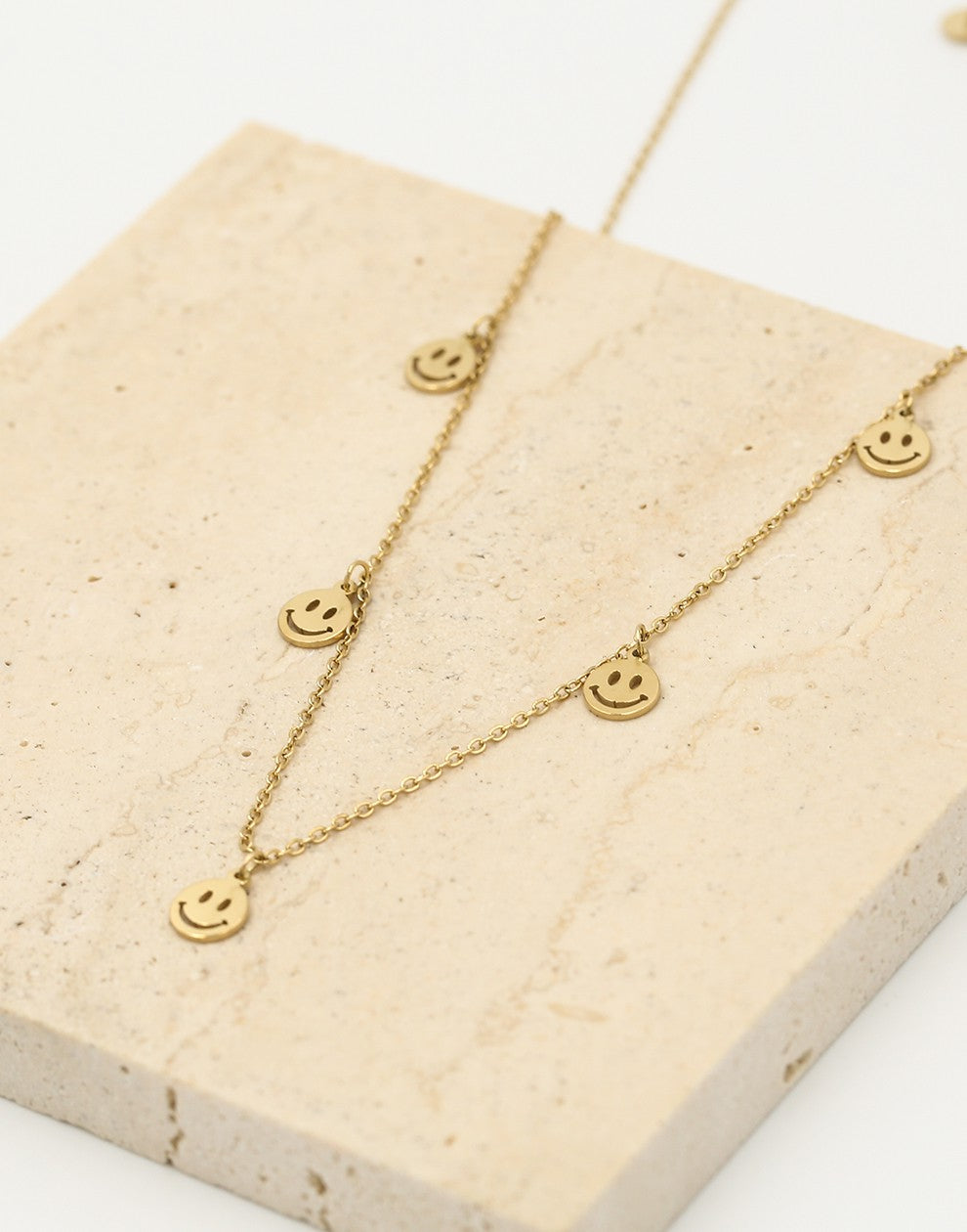 Fijne ketting met 5 smiley hangers goudkleurig