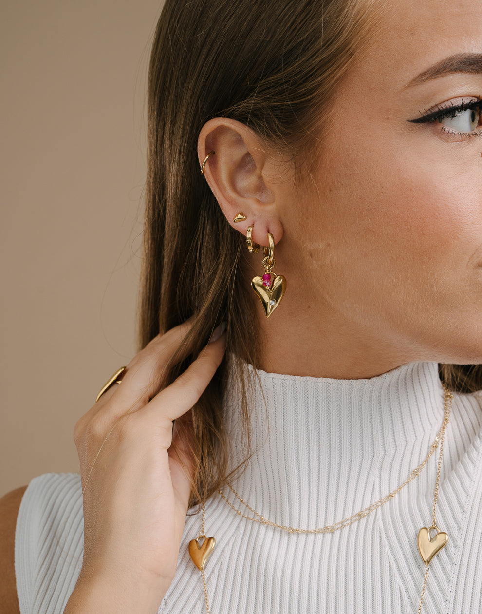 Herzförmige Creolen mit goldfarbenen Perlen