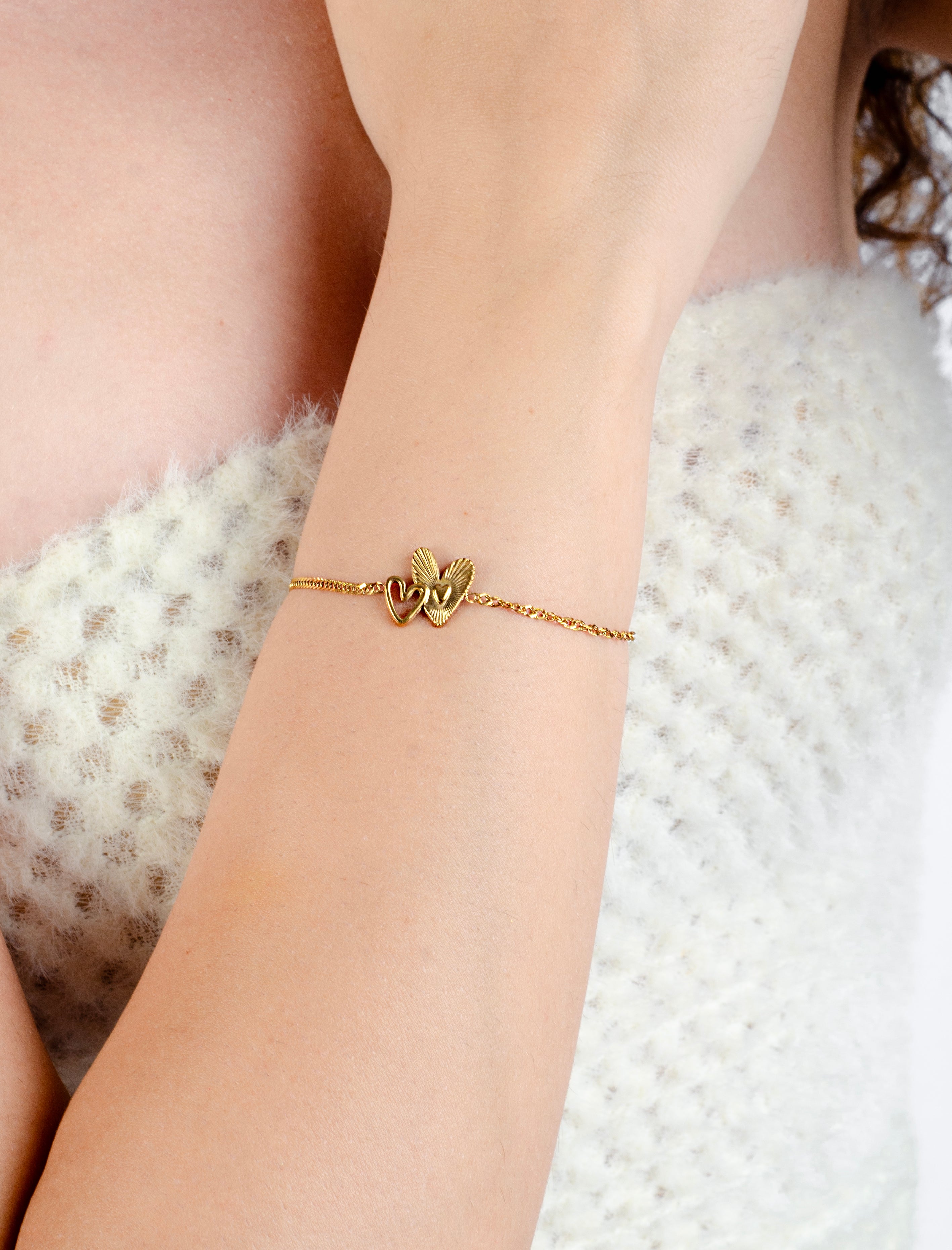 Armband verbonden speelse hartjes goudkleurig